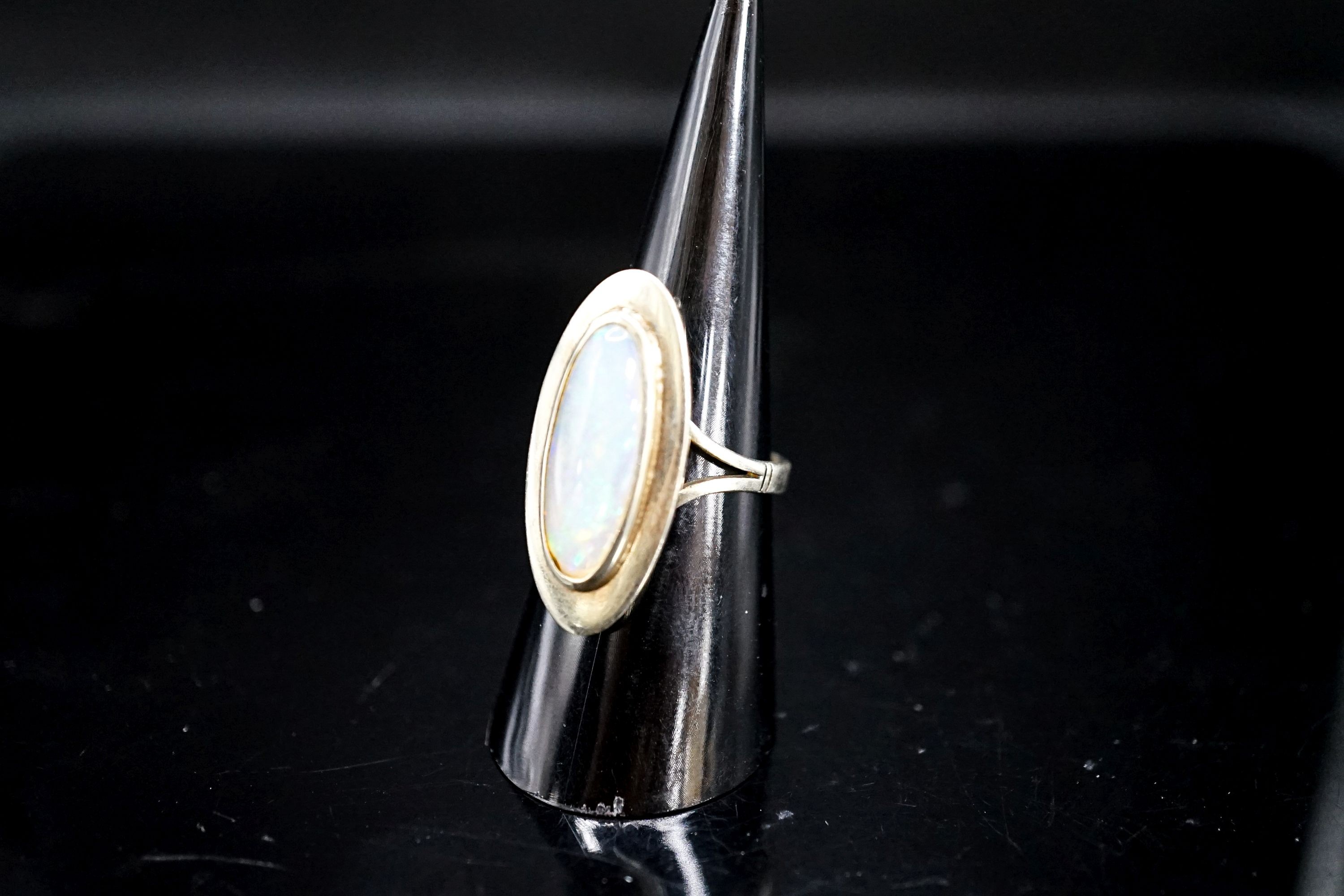 A 9ct white gold and oval cabochon white opal set dress ring